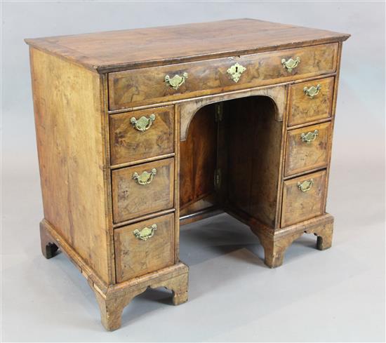 A George II featherbanded walnut kneehole desk, W.3ft 2.5in. D.1ft 10.5in. H.2ft 9in.